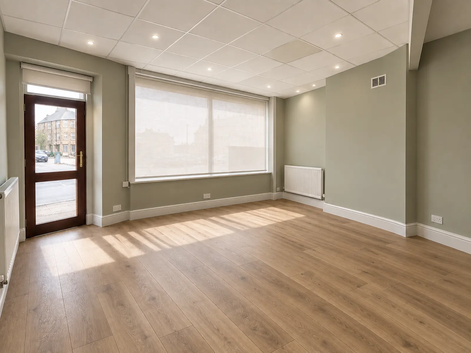 Visualisation of the corner room as Unit 1: oak floor, sage walls, a broad window and a glazed door onto the street